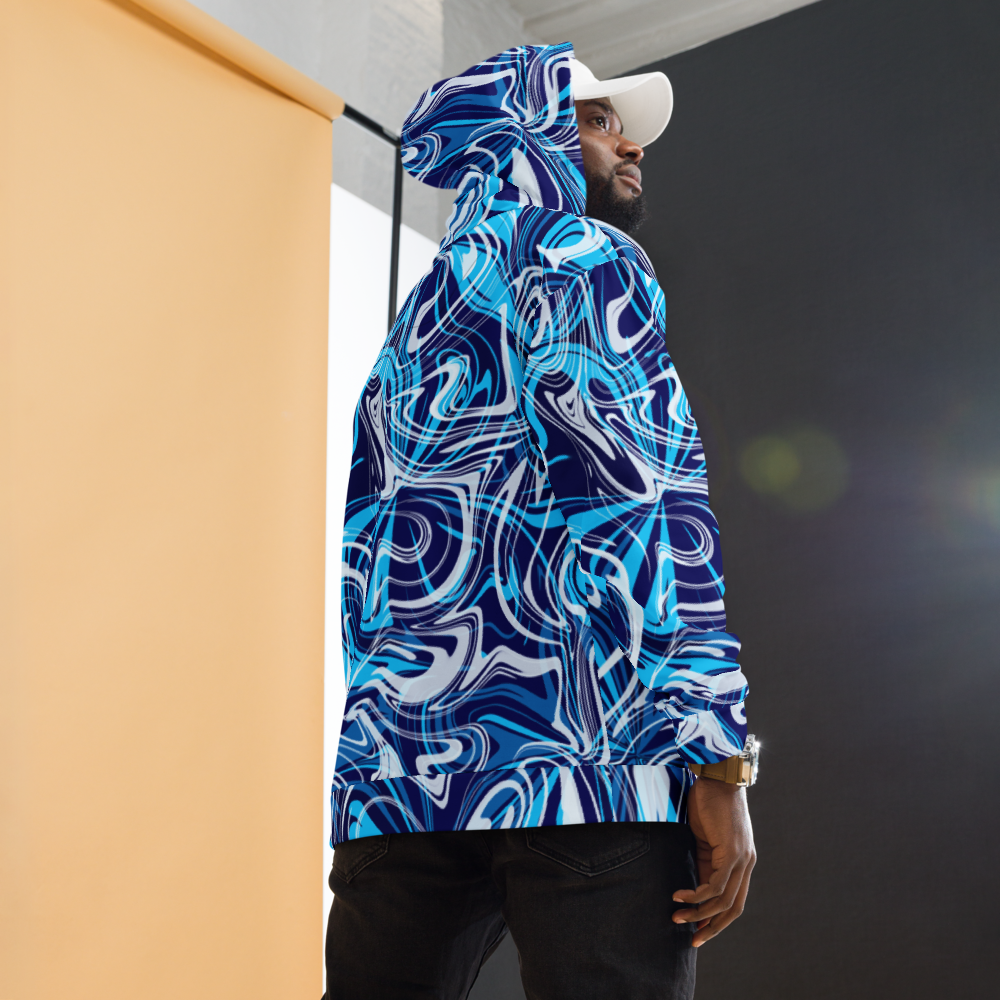 A man wearing a blue, white, and navy abstract swirl patterned hoodie with a relaxed fit. The design features bold, fluid lines that create a modern, artistic look. The photo shows the back and side view of the hoodie, highlighting its vibrant all-over print and hood detail.  He is also wearing dark pants and w white cap against a softly lit studio background. 